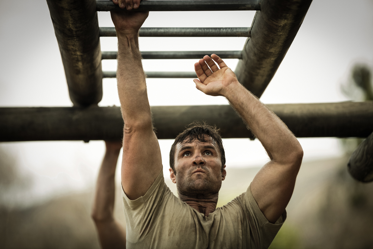Soldier climbing monkey bars in boot camp. Concept of PRK and LASIK approved for Military personnel 
